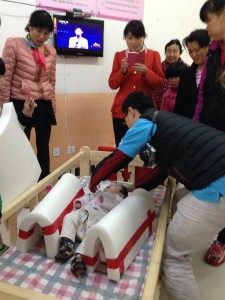 ZiLi Wang, Physical Therapist, demonstrates positioning at a welfare institute.